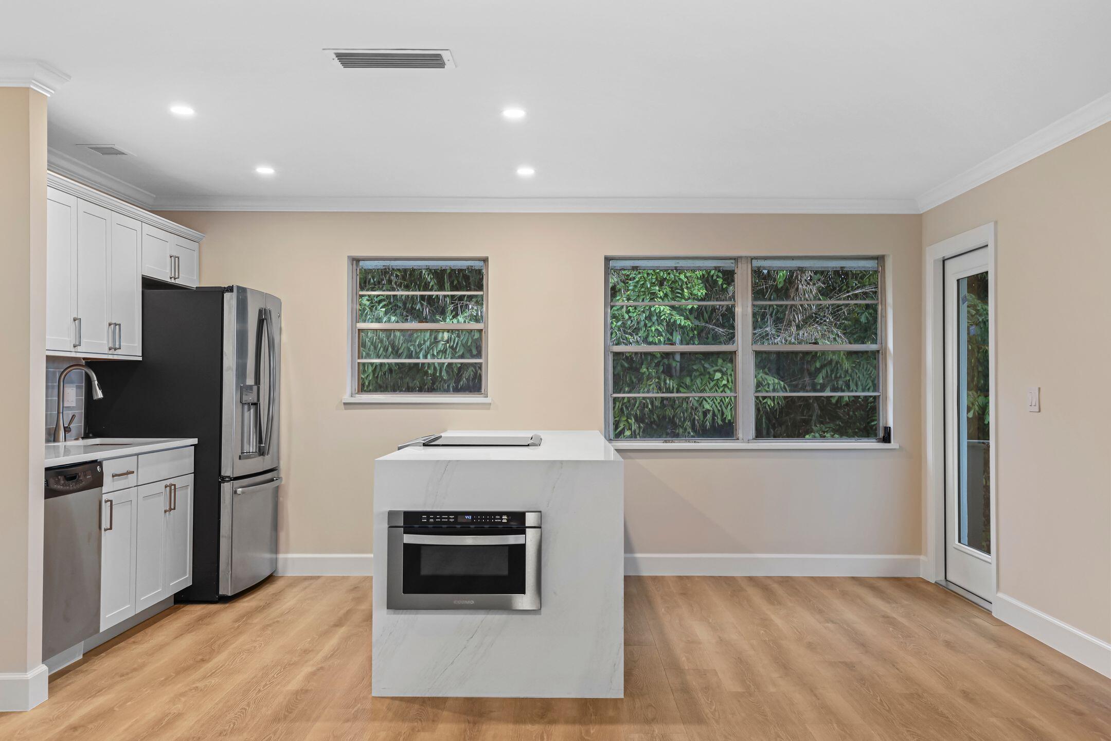 2929 Southeast Ocean Boulevard, Unit 1406 Stuart, FL 34996 - Photo 7 of 27 a view of kitchen with granite countertop cabinets and refrigerator
