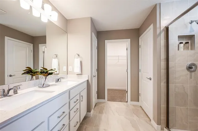 a spacious bathroom with double sink and a mirror