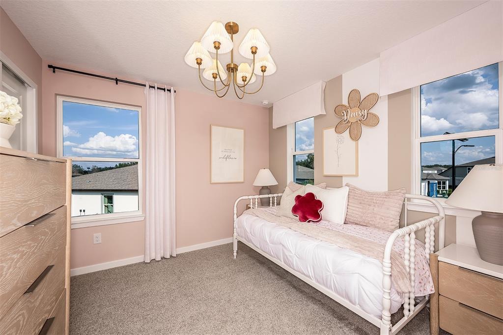 11346 Meadow River Way Parrish, FL 34219 - Photo 15 of 25 a bedroom with a bed a chandelier and a mirror