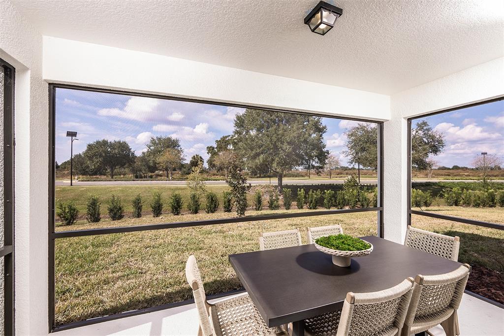 11346 Meadow River Way Parrish, FL 34219 - Photo 18 of 25 a view of a dining room with furniture large windows and wooden floor