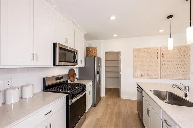 a kitchen with stainless steel appliances granite countertop a sink stove and refrigerator