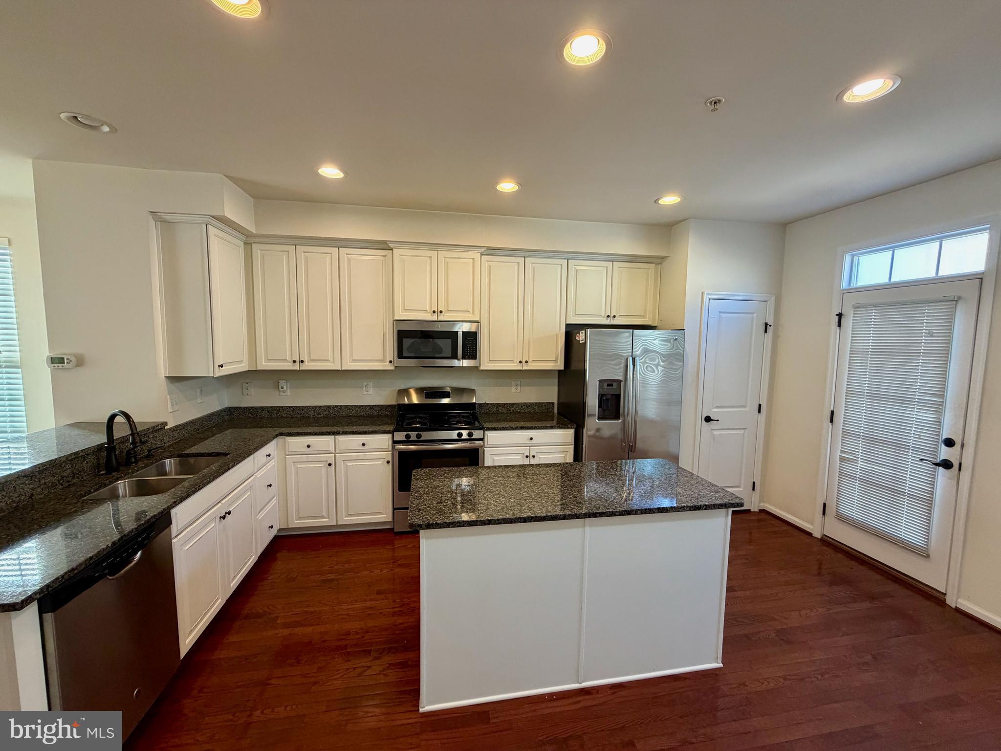 7729 Duncannon Lane Hanover, MD 21076 - Photo 12 of 26 a kitchen with stainless steel appliances granite countertop a refrigerator a sink a stove a microwave and wooden cabinets