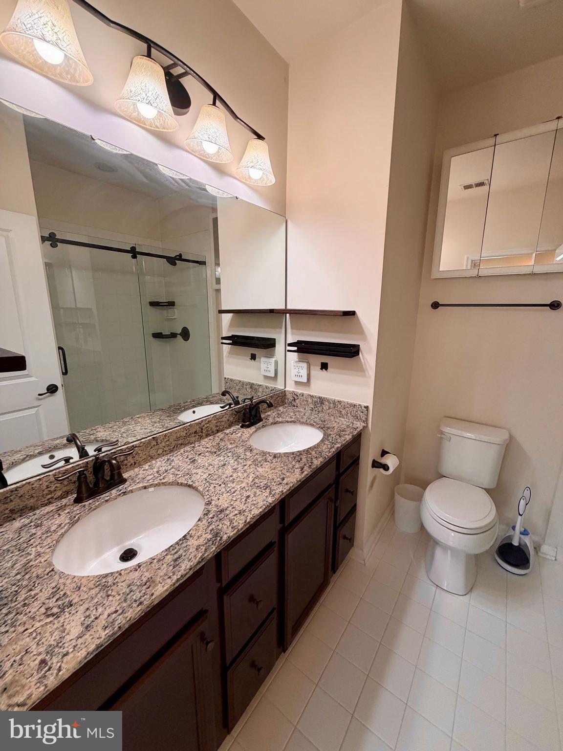 7729 Duncannon Lane Hanover, MD 21076 - Photo 19 of 26 a bathroom with a granite countertop sink a toilet and mirror