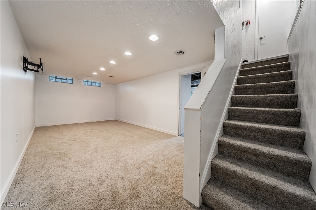 1235 Dorsh Road Cleveland, OH 44121 - Photo 26 of 39 Basement featuring recessed lighting, carpet flooring, stairs, and a textured ceiling