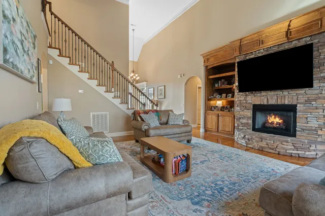 a living room with furniture a flat screen tv and a fireplace