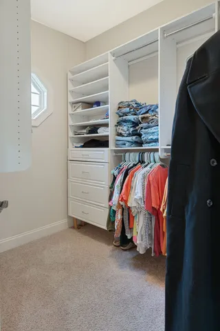 a view of walk in closet with clothes and shoes