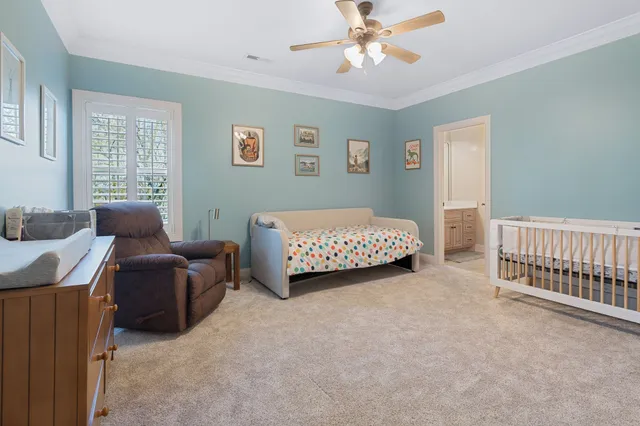 a living room with furniture and a baby crib