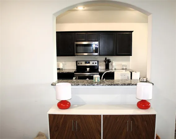 a kitchen with a sink a stove and cabinets