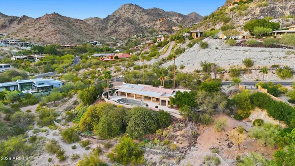an aerial view of house with yard and mountain view in back