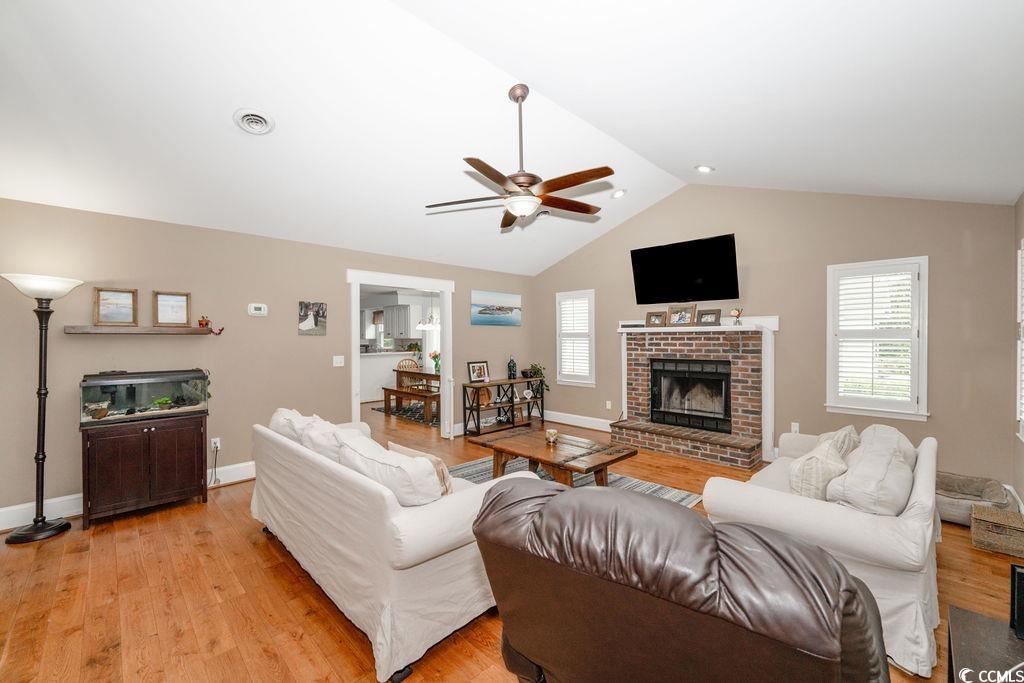 Living room with a brick fireplace, vaulted ceilin