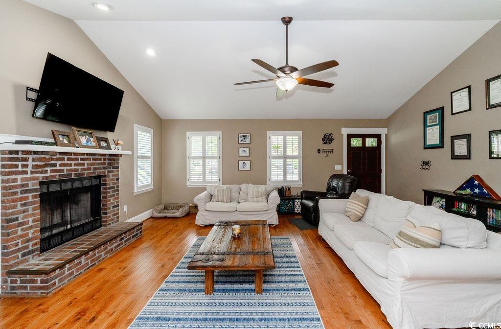 Living room with a brick fireplace, light wood-typ