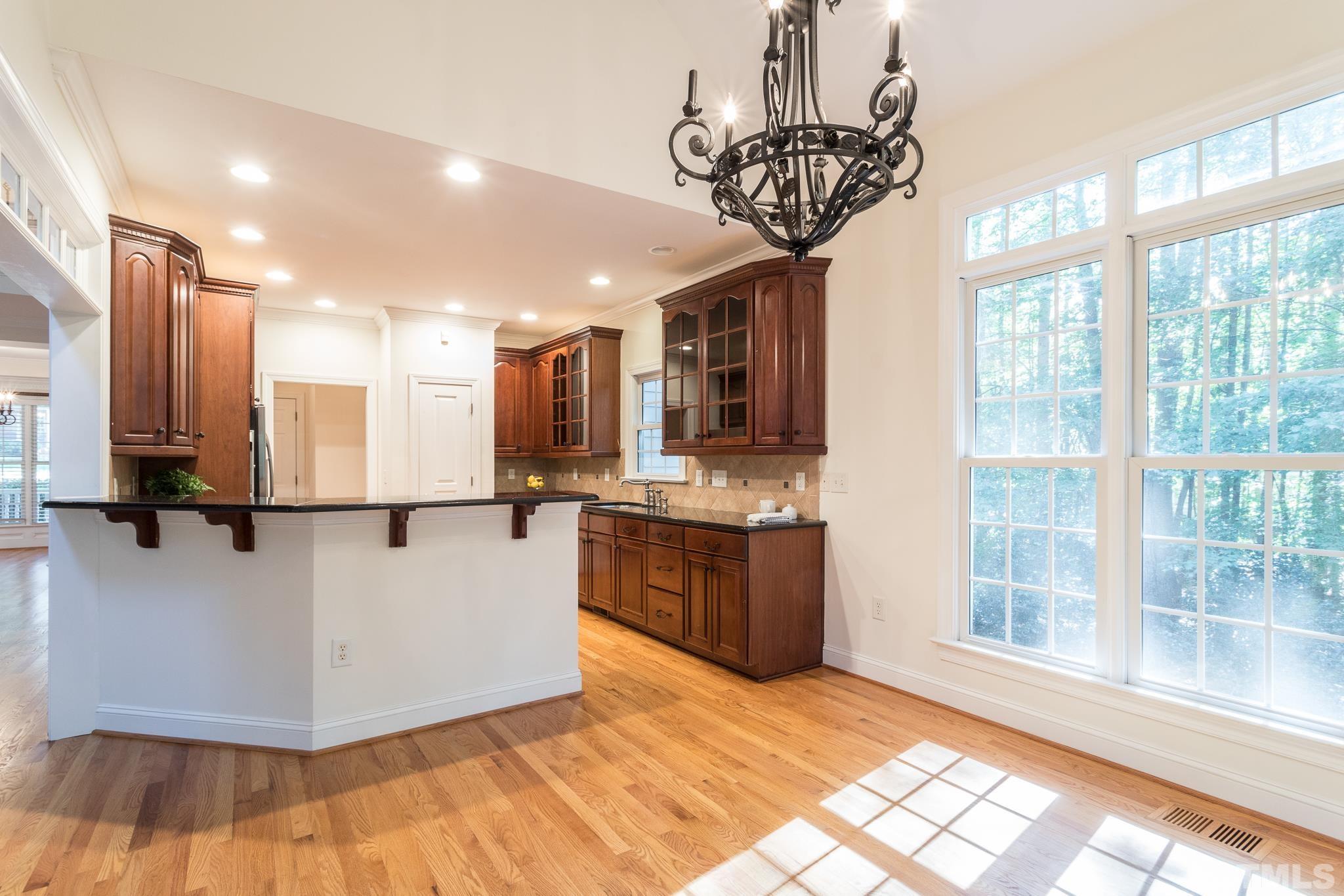 11625 John Allen Road Raleigh, NC 27614 - Photo 16 of 30 a kitchen with stainless steel appliances granite countertop a refrigerator a sink dishwasher a stove and a dining table with wooden floor