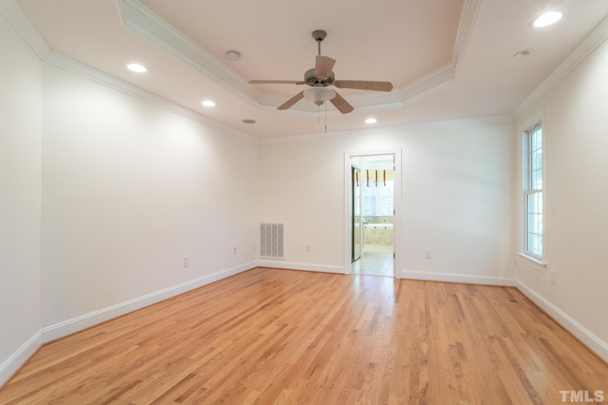 11625 John Allen Road Raleigh, NC 27614 - Photo 9 of 30 an empty room with wooden floor ceiling fan and windows