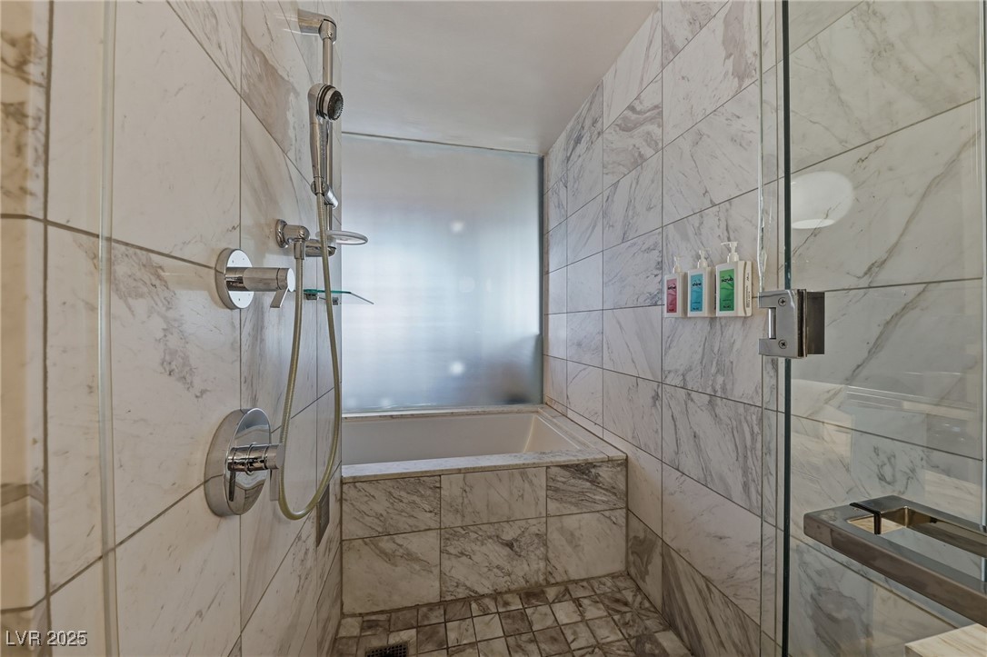 4381 West Flamingo Road, Unit 11308 Las Vegas, NV 89103 - Photo 14 of 26 Bathroom with a stall shower and tile walls