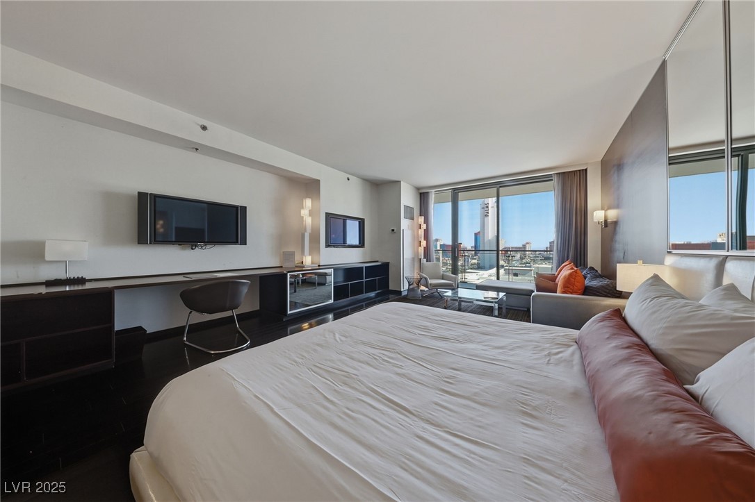 4381 West Flamingo Road, Unit 11308 Las Vegas, NV 89103 - Photo 5 of 26 Bedroom with access to exterior, floor to ceiling windows, and wood finished floors