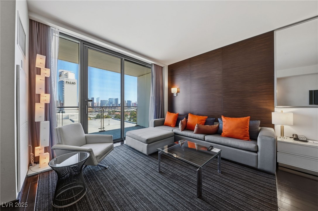 4381 West Flamingo Road, Unit 11308 Las Vegas, NV 89103 - Photo 9 of 26 Living room featuring a skyline view, a wall of windows, and dark wood-style floors