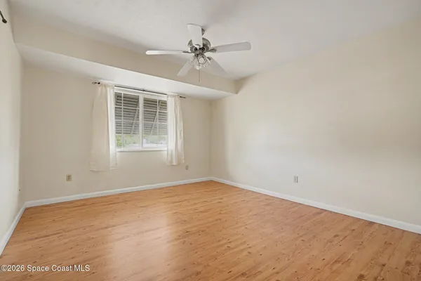 a view of empty room with wooden floor