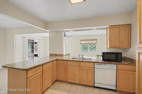 a kitchen with granite countertop white cabinets and stainless steel appliances