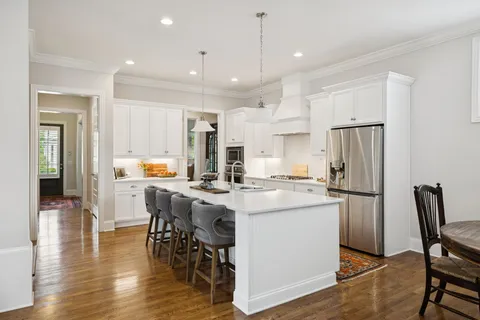 a kitchen with stainless steel appliances white cabinets and wooden floor