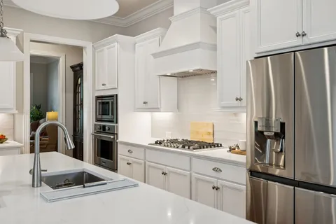 a kitchen with sink stove and chairs