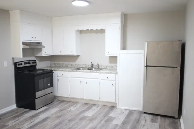a kitchen with a refrigerator stove and white cabinets