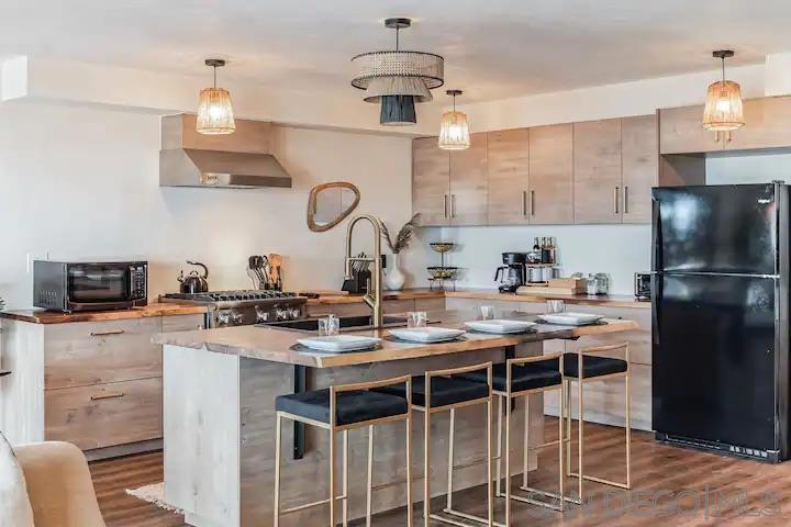 5639 La Jolla Boulevard La Jolla, CA 92037 - Photo 15 of 15 a kitchen with kitchen island granite countertop a sink cabinets a stove and a refrigerator