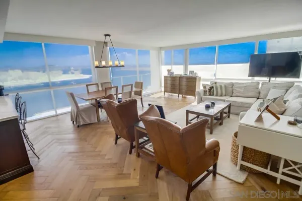 a dining room with furniture a chandelier and kitchen view