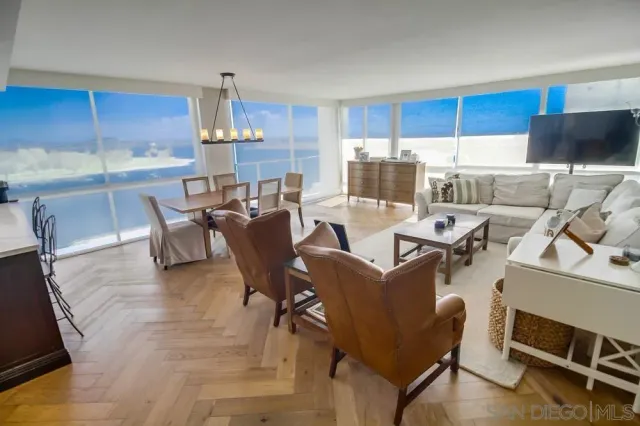 a dining room with furniture a chandelier and kitchen view