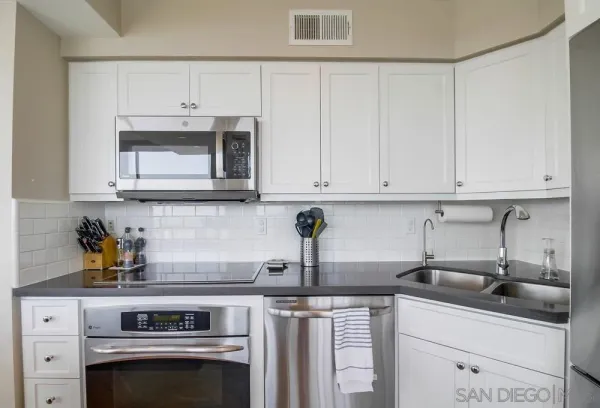 a kitchen with stainless steel appliances granite countertop a sink a stove and cabinets