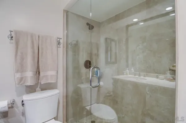 a bathroom with a shower a toilet and sink