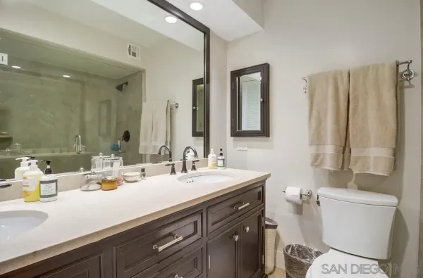 a bathroom with double sink and a mirror