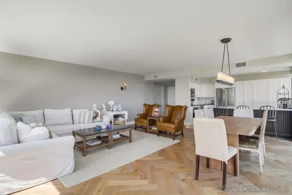 a living room with furniture a chandelier and a dining table