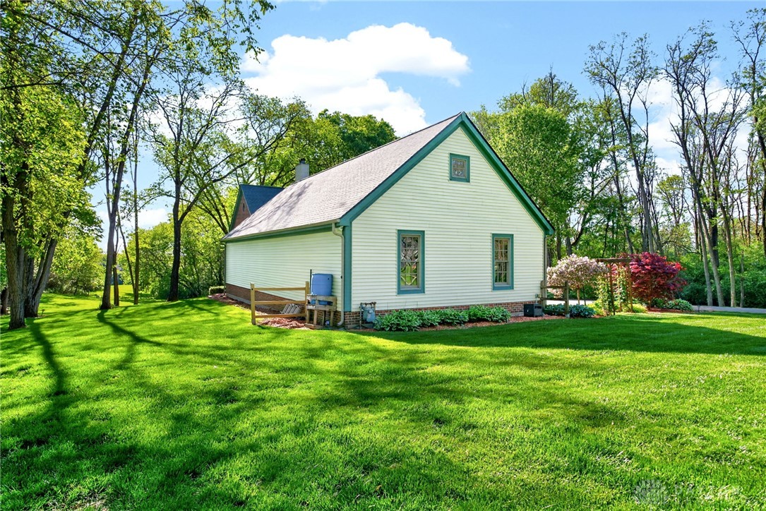 330 South Alpha Bellbrook Road Bellbrook, OH 45305 - Photo 64 of 87 This charming home offers a serene escape with its lush greenery and timeless architecture.