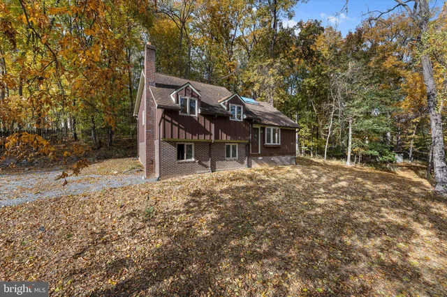 a backyard of a house with large trees and table