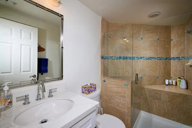 a bathroom with a sink a toilet and shower