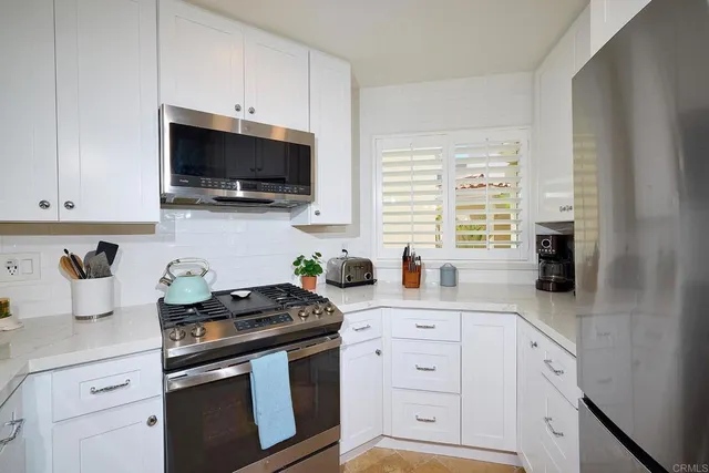 a kitchen with stainless steel appliances granite countertop a sink a stove and a microwave