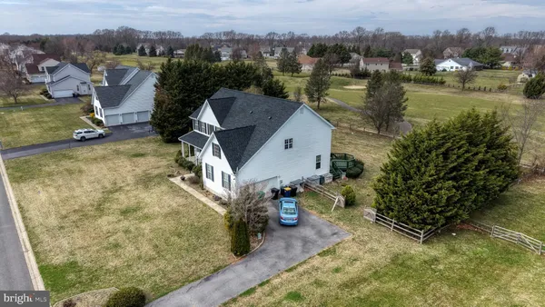an aerial view of residential houses with outdoor space and parking