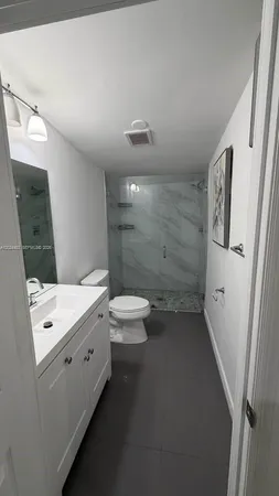 a bathroom with a double vanity sink toilet and shower