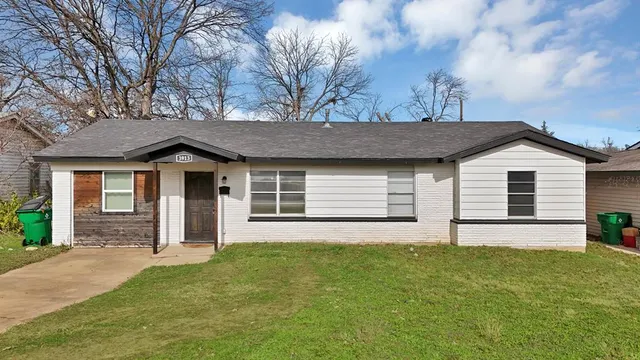 a front view of a house with a garden and yard