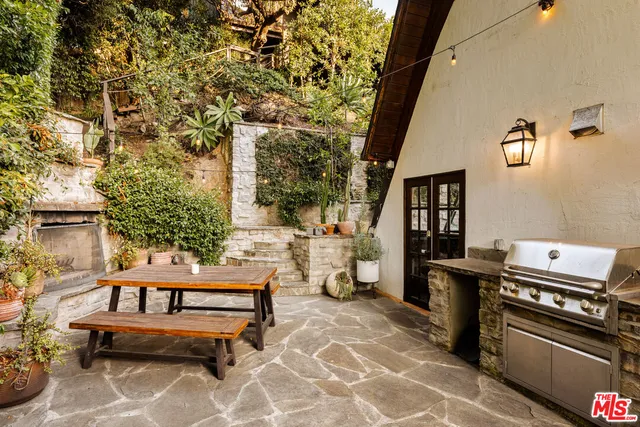 a roof deck with table and chairs and potted plants