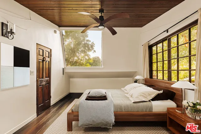 a bedroom with a bed next to a window