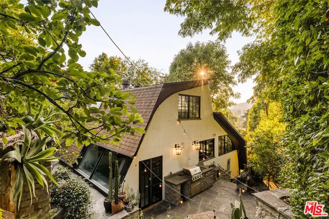 a view of house with backyard and sitting area