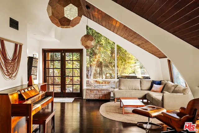 a living room with fireplace furniture and a large window