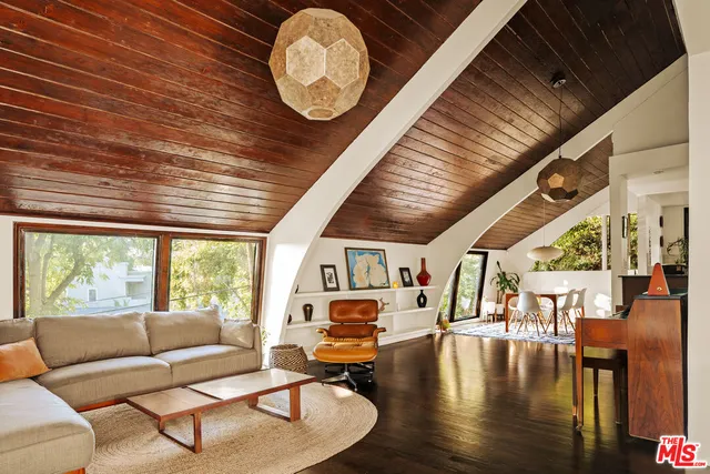a living room with furniture wooden floor and a large window