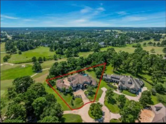 an aerial view of residential houses with outdoor space and trees