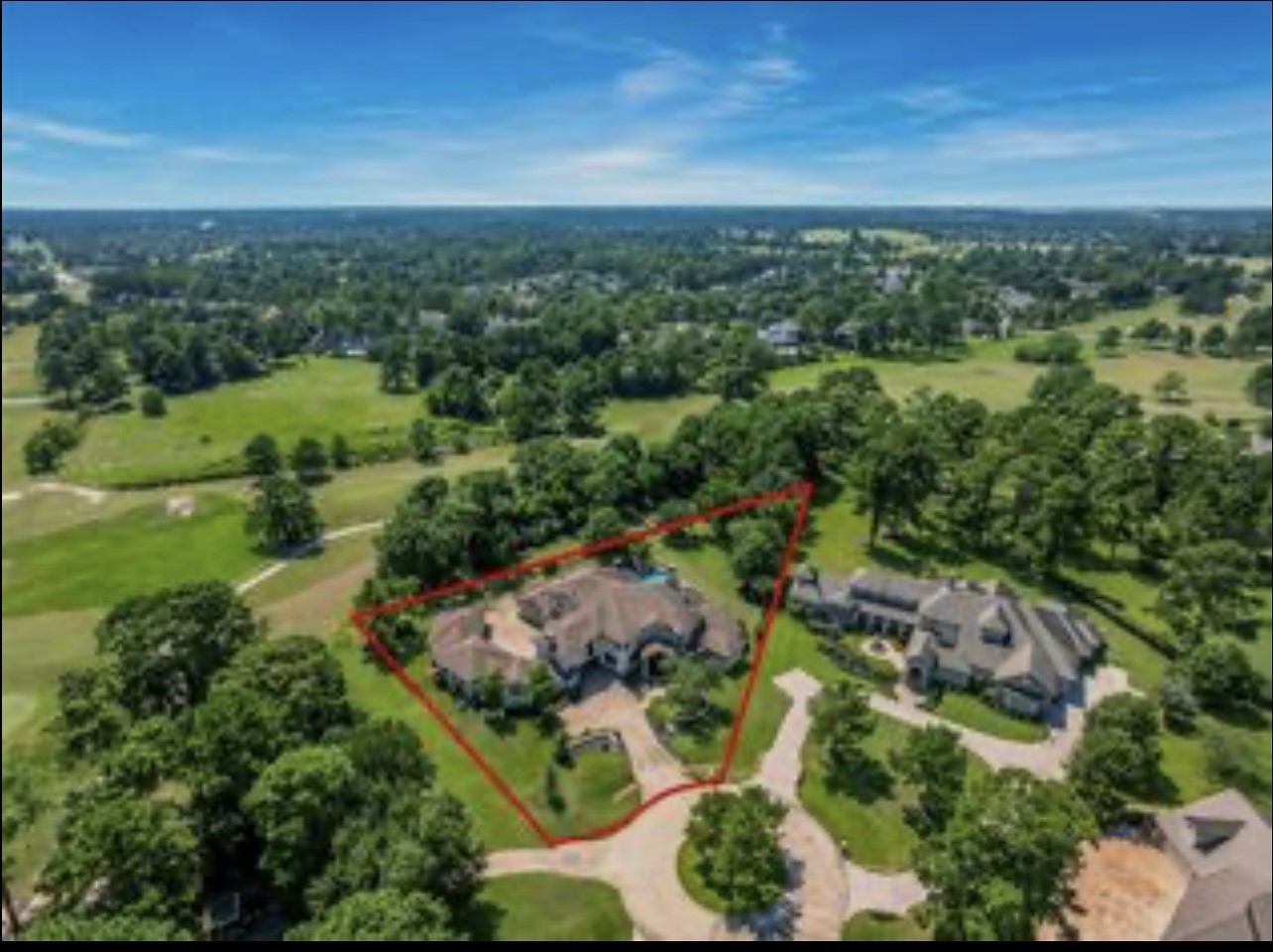 an aerial view of residential houses with outdoor space and trees