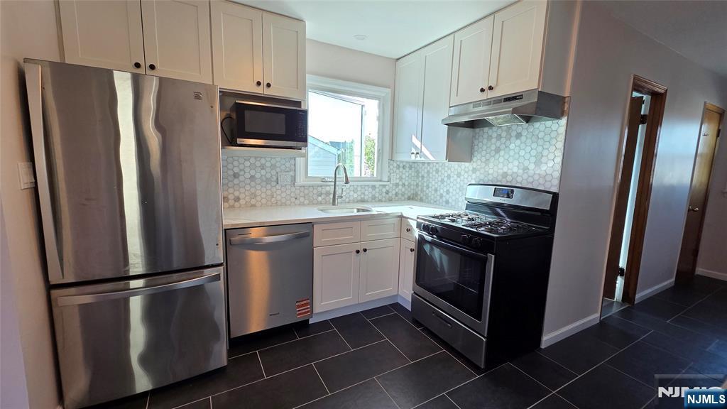 159-161 Tappan Street, Unit TOP Kearny, NJ 07032 - Photo 2 of 12 a kitchen with stainless steel appliances a refrigerator sink and microwave