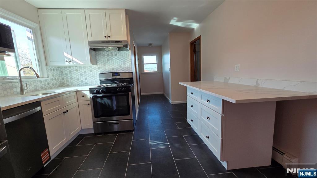 159-161 Tappan Street, Unit TOP Kearny, NJ 07032 - Photo 3 of 12 a kitchen with stainless steel appliances a stove sink and cabinets
