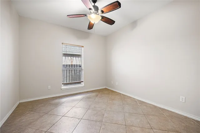 an empty room with a chandelier fan and glass door