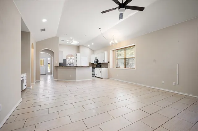 a view of a livingroom with a chandelier fan and windows